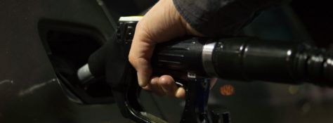 A person refilling their car with gasoline